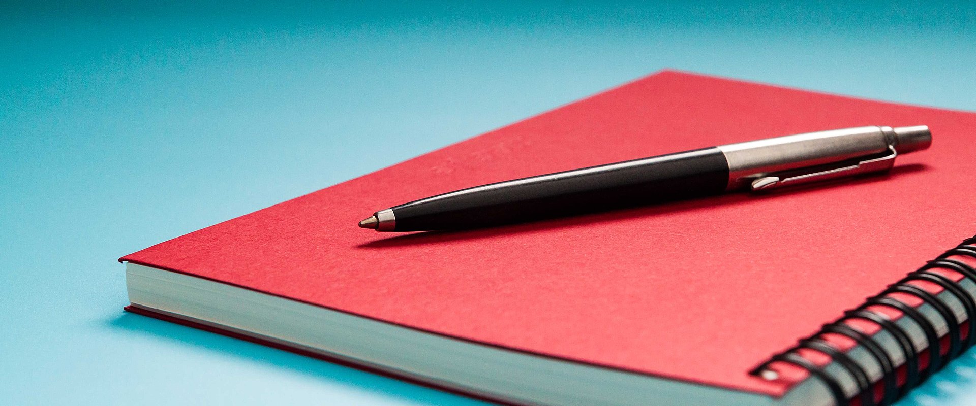 Stift auf rotem Notizbuch